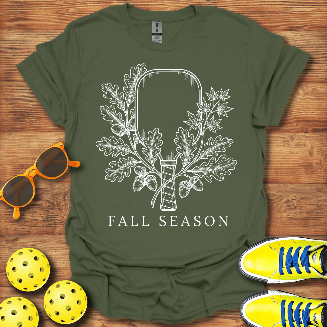 An olive green short-sleeve t-shirt with a white graphic of a hammer encased in oak leaves and acorns, with the text 'FALL SEASON' underneath. 